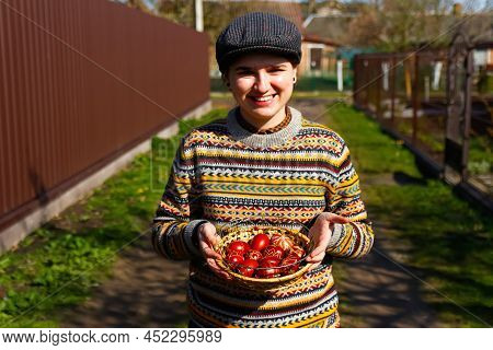 Defocus Ukrainian Young Smiling Woman In Hat Holding Plate Of Collection Of Red Egg On Nature Backgr