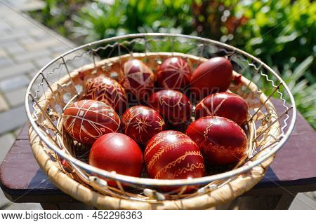 Defocus Closeup Of Basket Of Colored Red Eggs, Easter Holiday Concept. Modern Painted Easter Eggs. N