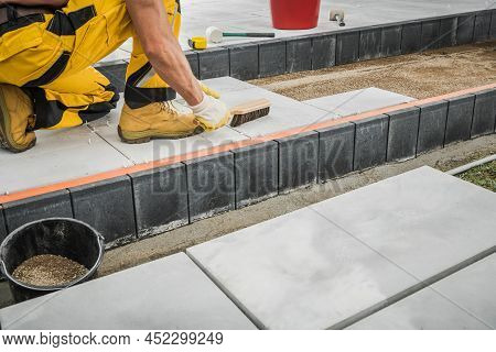 Residential Backyard Garden Concrete Bricks Paving Performed By Professional Caucasian Worker Close 