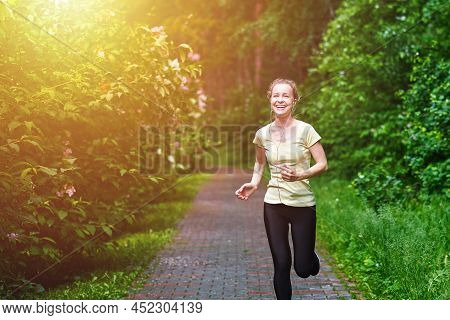 Running Woman Atletic Spotsman Trains In The Summer Park. Outdoor Fitness Portrait After Rain