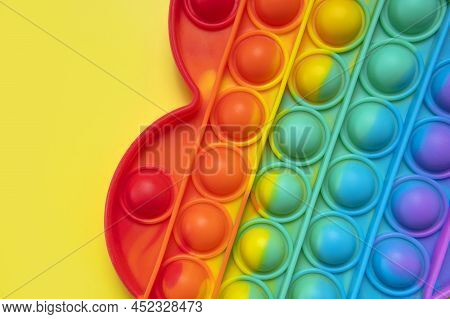 Popular Silicone Multi-colored Anti-stress Toy Pop It In The Shape Of Heart On Yellow Background Fla