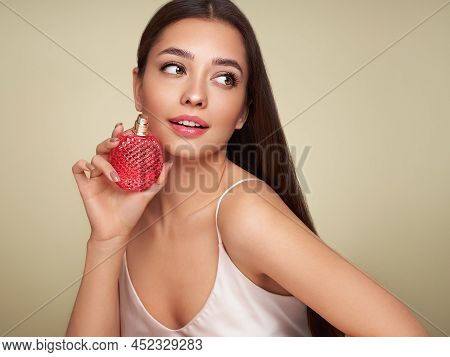 Young Beautiful Woman With A Bottle Of Perfume. Model With Healthy Skin, Close Up Portrait. Cosmetol