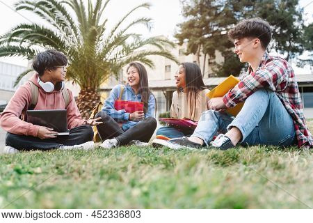 Group Of Multiracial International Exchange University Student Friends Sitting On The Grass In The C