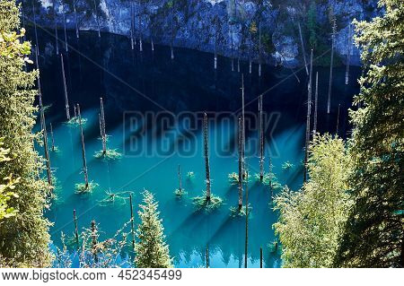 Landscape Of A Mountain Lake With Trunks Of Flooded Fir Trees. Kaindy Lake In Kazakhstan. Kolsay Lak