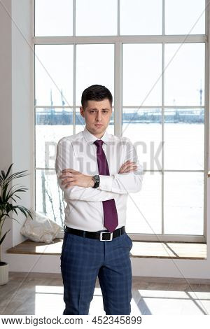 Portrait Of A Businessman. Office Worker In A White Shirt And Tie Looking At The Camera