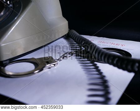 Handcuffs On Top Secret Document In Dark Room