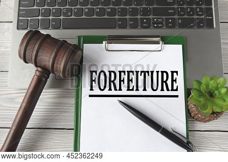 Forfeiture - Words On A White Sheet On The Background Of A Laptop, A Court Hammer And A Pen. Busines