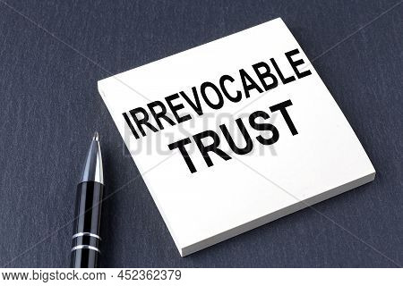 Irrevocable Trust Text On Sticker With Pen On The Black Background
