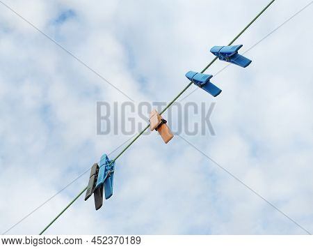 Clothes Pins On A Clothes Line Rope. Clothespins Hanging On A Washing Line Under Tropical Cloudy Sky