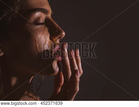 Beautiful Woman With Honey Flows Down On Her Face. Portrait Of Girl With A Honey Facialmask Closeup.
