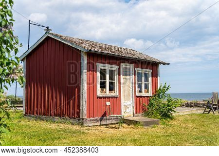 Red Wooden Fishing Scandinavian Buildings Over The Fjord. Black And Green Roofs. The Coast Of Centra