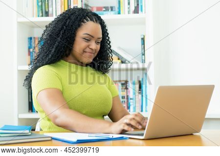 Corpulent African American Female Student Learning At Computer Indoors At Home