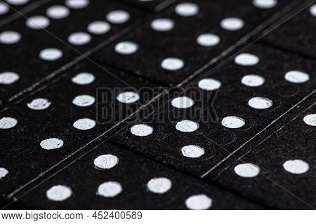 Black Dominoes On Dark Background, Closeup Scattered Dominoes On A Gray, Table. Board Game, Game Nig