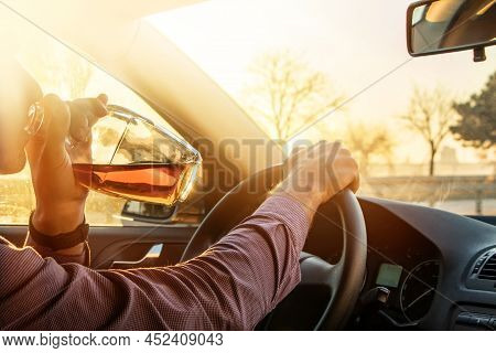 Man Drinking Alcohol While Driving In His Car On Sunset.