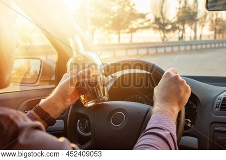 Man Drinking Alcohol While Driving In His Car On Sunset.