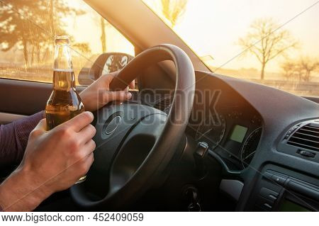 Man Drinking Alcohol While Driving In His Car On Sunset.