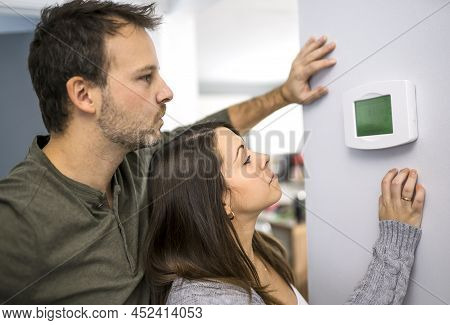 Nice Couple Set The Thermostat At Home