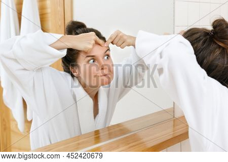 Young Woman Squeeze Pimples In The Bathroom