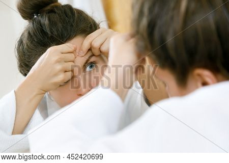 Young Woman Squeeze Pimples In The Bathroom