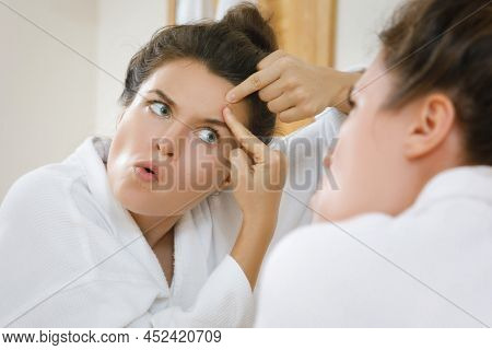 Young Woman Squeeze Pimples In The Bathroom