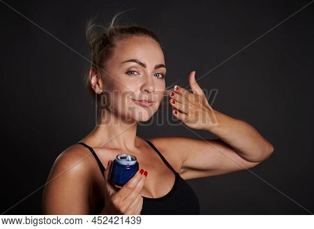 Charming Beautiful Young Woman Using Moisturizer Cream Or Lotions To Enhance The Appearance Of Her F