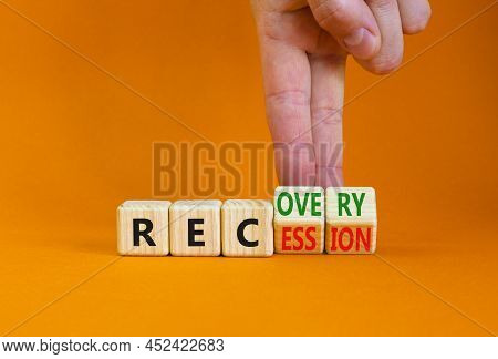 Recovery And Recession Symbol. Businessman Turns Cubes And Changes The Word 'recession' To 'recovery