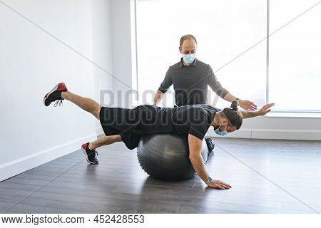 Physiotherapist Doing Therapeutic Exercises For Patient At The Clinic.