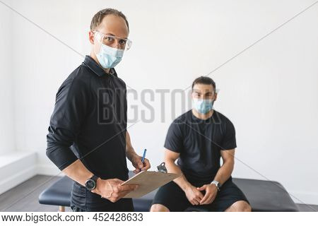Physiotherapist Doing Therapeutic Exercises For Patient At The Clinic.