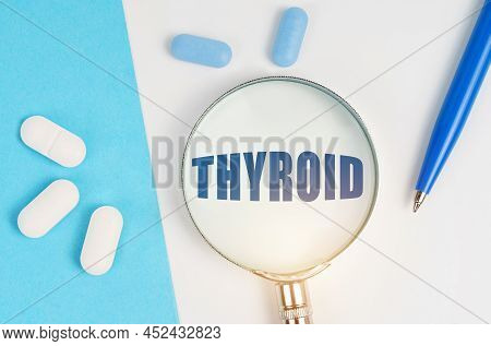 Medical Concept. On A White And Blue Surface Are Pills, A Pen And A Magnifying Glass With The Inscri