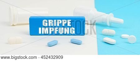 Medical Concept. On A White And Blue Surface Are Pills, A Spray And A Wooden Sign With The Inscripti