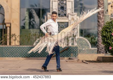 Spanish Flamenco Dancer Dressed In Blue And White Moving A Manton Around His Body