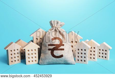 Ukrainian Hryvnia Money Bag Among Town Houses Figurines. Municipal Budgeting. Rental Business. Realt