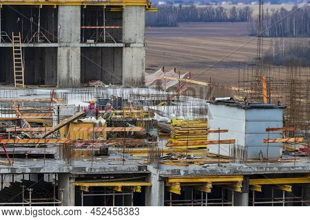 Monolithic Frame Construction Of The Building. Workers Working At The Construction Site At Home. The