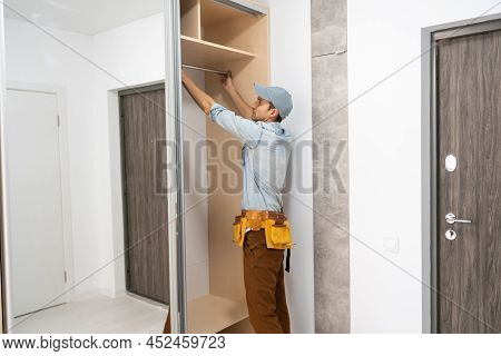 Repairman Installs A Sliding Door Wardrobe With A Mirror
