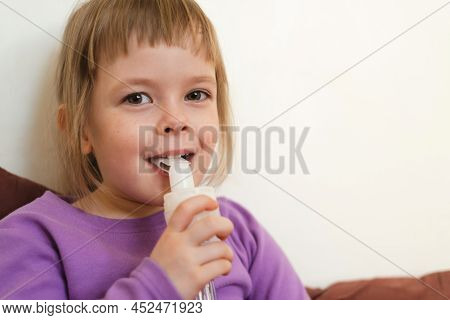 Sick Child Lies In Bed And Makes Inhalation Using A Nebulizer. Portrait Of A Smiling Child With A Ne
