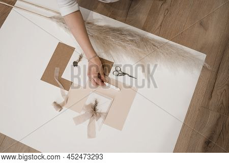 Top View Of Composition Of Sheets Of Paper, Scissors, Envelope With Grey Wax Seal, Bow Of Rink Ribbo