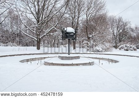 Moscow. Russia. April 3, 2022. Snow-covered Frozen Fountain In The City Park. Fountain With A Sculpt