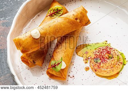 Deep fried popiah popia roll wraps with dipping sauce.