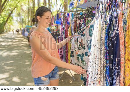 Woman With Colorful Clothes Outdoors At Typical Traditional Market Shopping