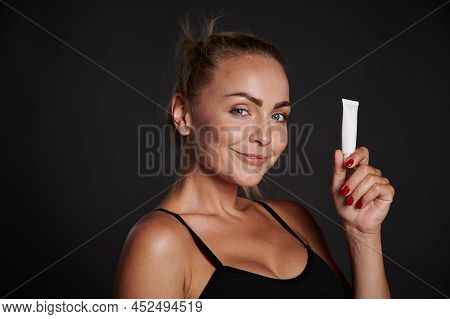 Beautiful Caucasian Woman With Tanned Skin Holding A Tube Of Anti Wrinkles Smoothing Anti Puffiness 