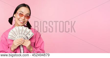 Beautiful Korean Woman In Sunglasses, Showing Dollars, Money Cash, Smiling Pleased, Concept Of Fast 