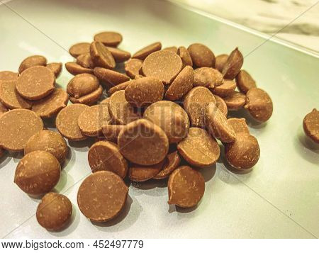 Chocolate Callets Background. The Concept Of Tempered Chocolate Confectionery. Cooking Chocolates By