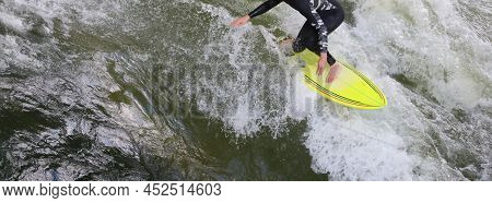 Young Surfer With Surfboard While Riding The Wave