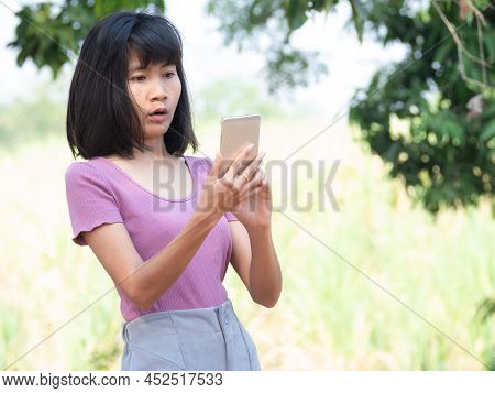 Woman Shock While Looking Mobile. Lady Use Smartphone And Surprised White Video Chat To Friend On Bl