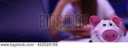 Close-up Of Piggy Bank On Desk, Broken Woman Count Money On Background. Saving Up For Tomorrow, Pay 