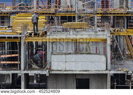 Monolithic Frame Construction Of The Building. Workers Working At The Construction Site At Home. The