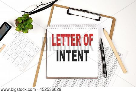 Office Desk Table With A Paper Sheet, Notepad ,chart And Calculator. Top View Loi - Letter Of Intent