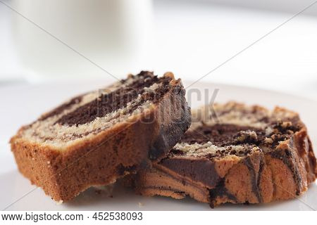 Close Up View Of Marble Cake Slice On White Plate And Wooden Table. High Quality Photo