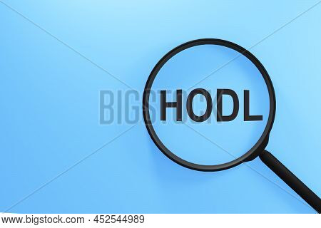 Word Hodl Through Magnifying Glass On Blue