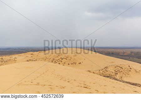 Sarykum Dune. Dagestan, Russia. A Unique Sandy Mountain In The Caucasus On A Cloudy Day. Grass Grows